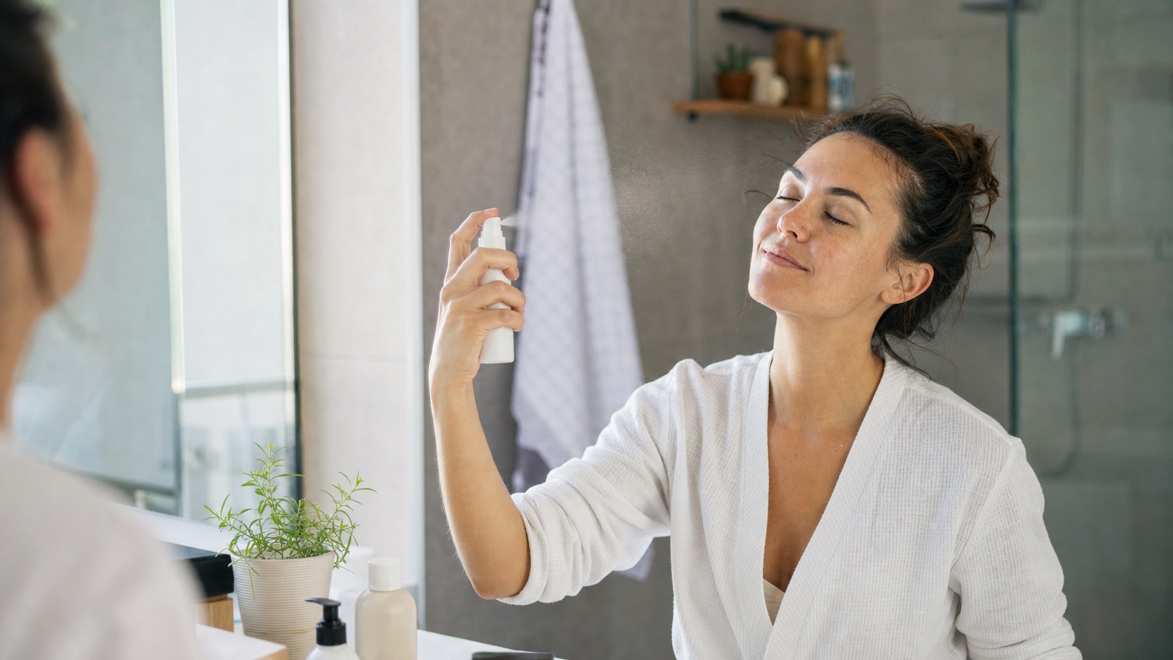 Woman using a face mist in a bathroom routine